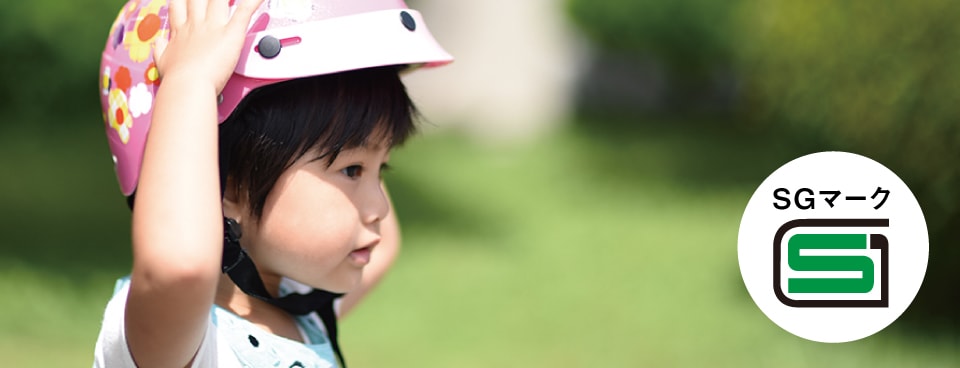ヘルメットをかぶった子どもの写真／SGマークのロゴ